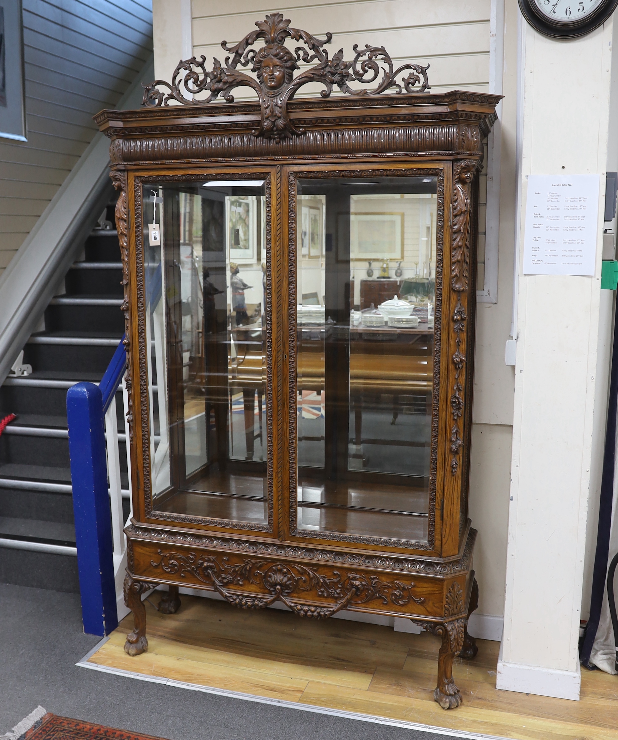An early 20th century George I style carved walnut vitrine, width 138cm, depth 50cm, height 218cm